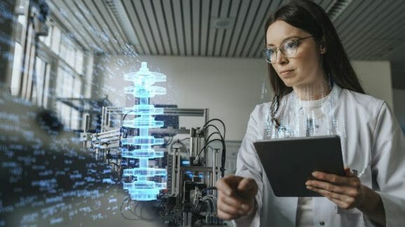 Female engineer with digital tablet examining development of industrial product