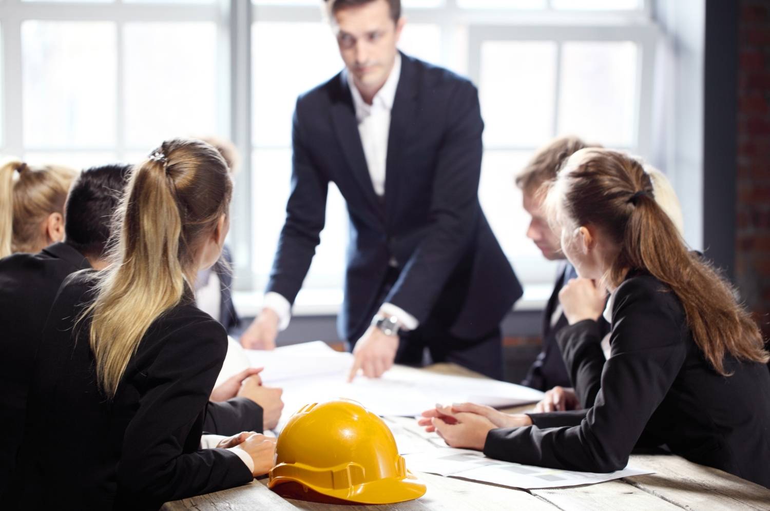 Business people group on meeting with constructin company looking at building blueprint