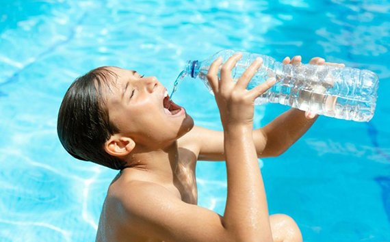 Summer Heat Image of Boy Drinking Bottled Water in Pool
