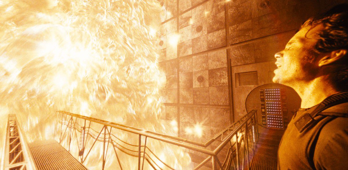Een man (Cillian Murphy) die op de binnenbrug van een ruimteschip staat en zich schrap zet om overspoeld te worden door een muur van vlammen.