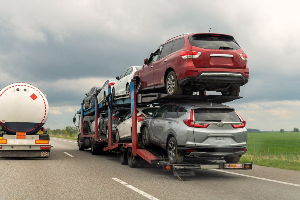Semiremorcă transport auto remorcher pe autostradă care transportă lot de mașini avariate vândute la licitațiile de mașini de asigurare pentru reparație și recuperare. Serviciu de transport și salvare autovehicule