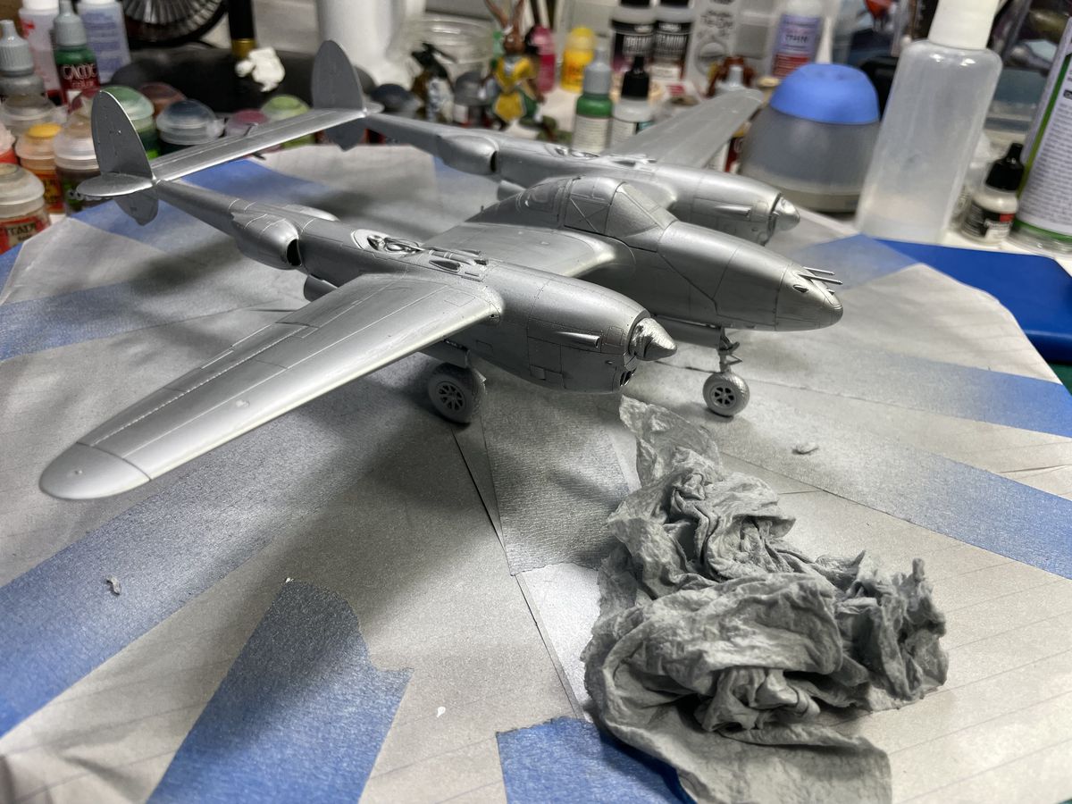 A shiny silver airplane on a lazy susan, a dirty rag in the foreground.