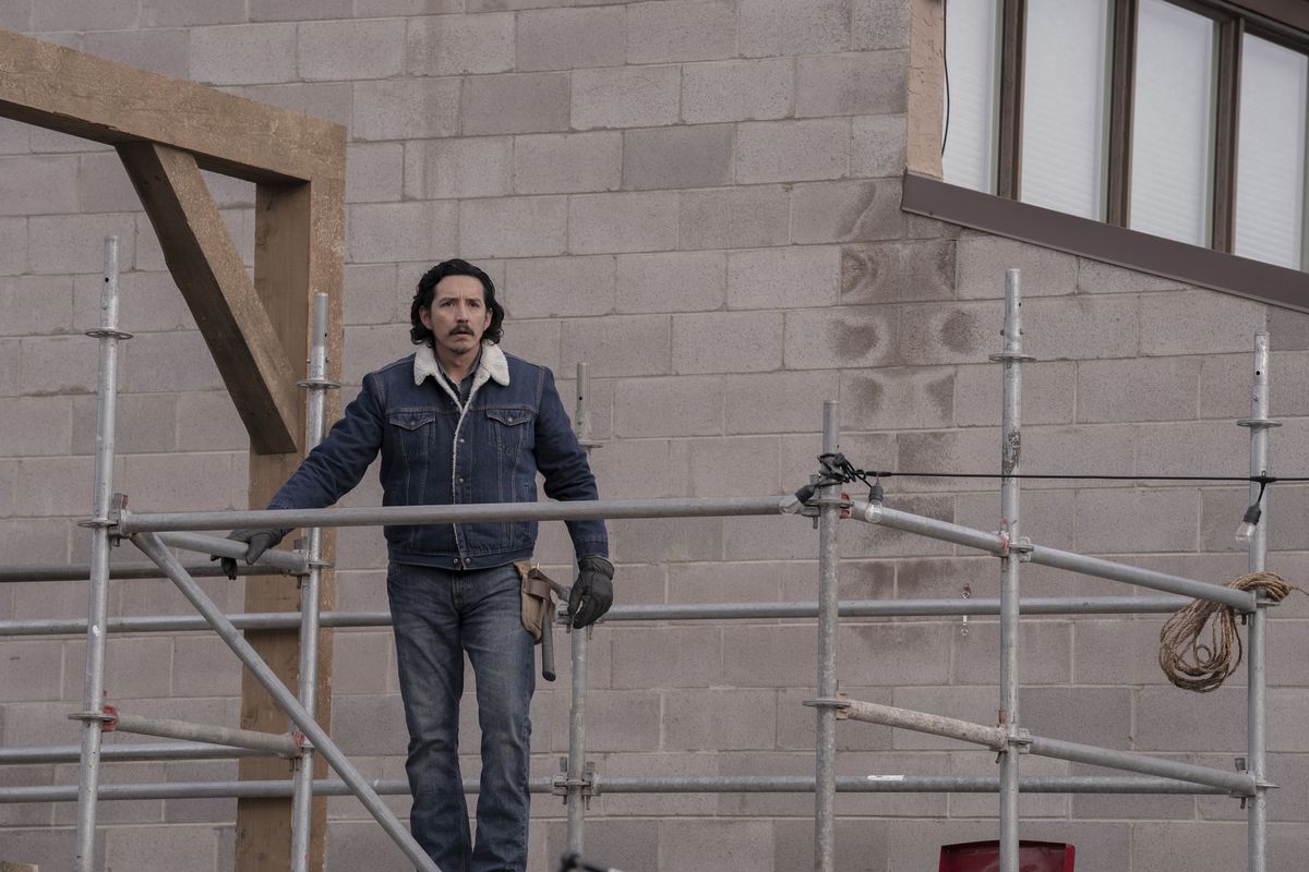 Gabriel Luna stands on top of some rafters while wearing a denim jacket in The Last of Us.