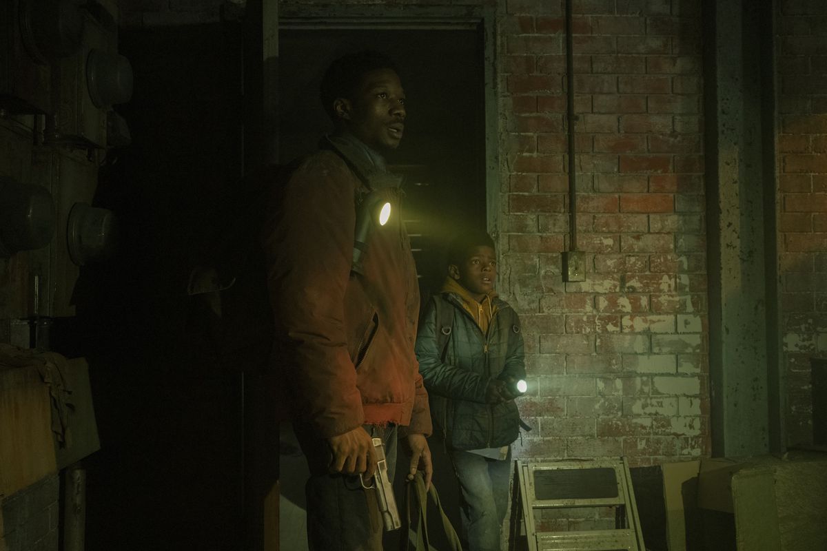 Henry (Lamar Johnson) and Sam (Keivonn Woodard) looking at something surprised; Sam is holding a flashlight while Henry has one strapped to his bag strap