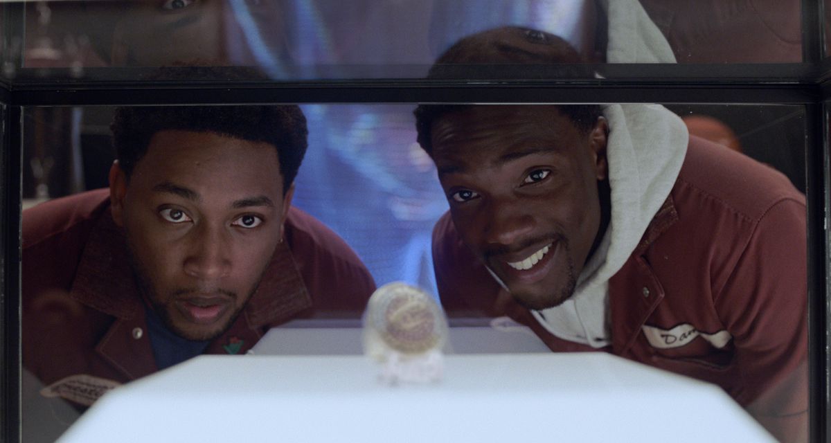 Le due star di House Party guardano uno degli anelli del campionato di LeBron James in una teca di vetro in House Party.