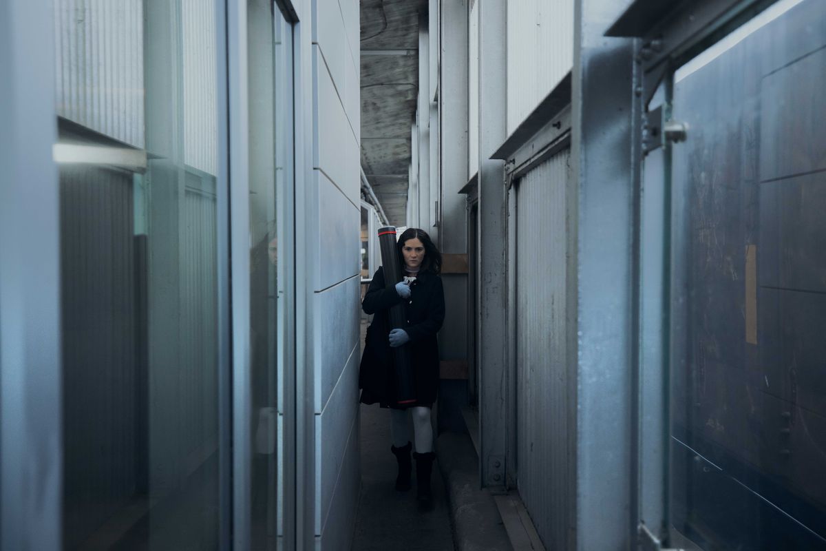 Isabelle Fuhrman como Esther en Orphan: First Kill caminando en una estación de tren