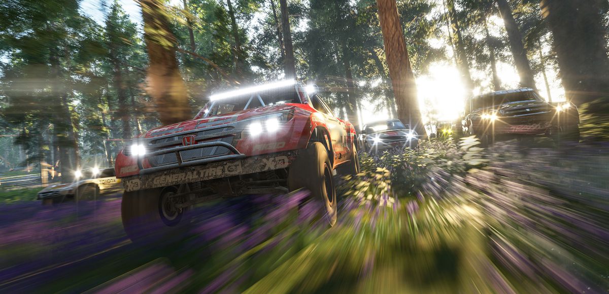 Forza Horizon 4 — offroad vehicles with lights blazing drive through a rugged forest