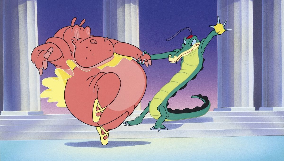 An animated hippo in a tutu and and ballet shoes an alligator in a red cap with a long feather dance together in an animated segment from Disney’s Fantasia
