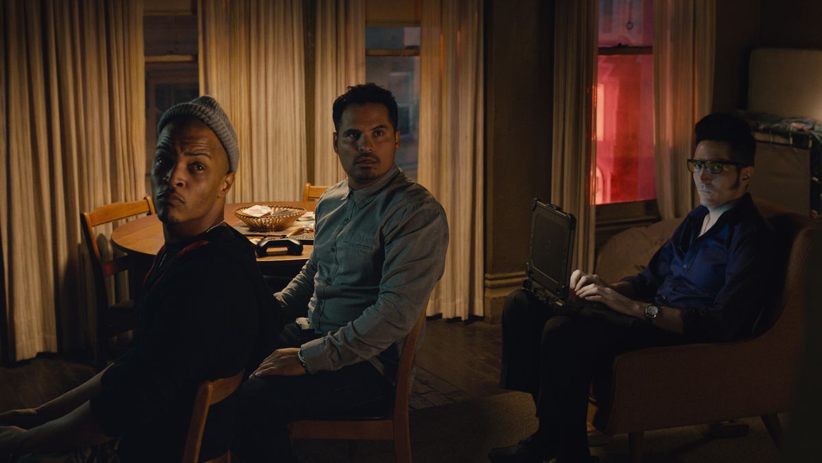 Dave (Tip “T.I.” Harris), Luis (Michael Peña), and Kurt (David Dastmalchian), Scott Lang’s crime crew, sit in a generic room looking over their shoulders at the camera in Ant-Man