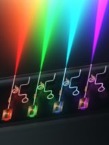 Illustration of the integrated laser platform showing different colours of visible light emerging from a single chip