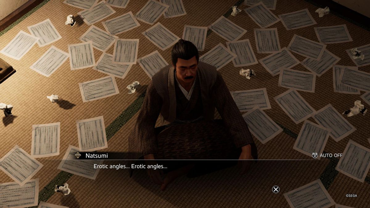 A man sits on a floor surrounding by many pages of a mediocre manuscript in Like a Dragon: Ishin!