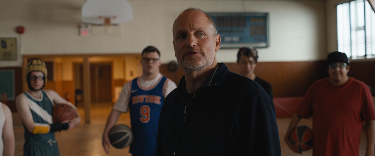 Woody Harrelson stands in front of his team in Champions on a basketball court.