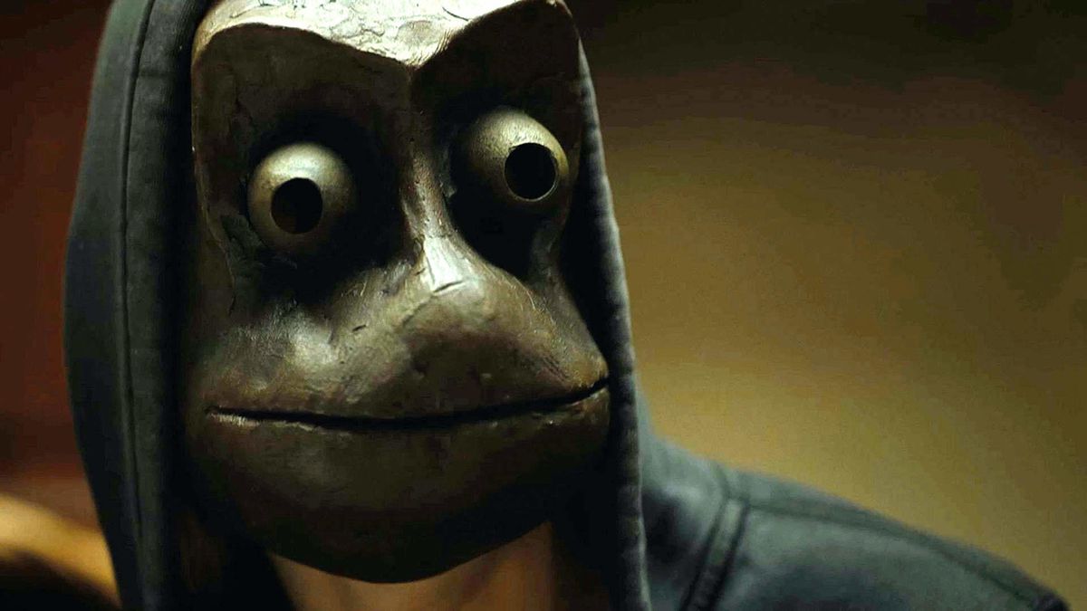 A man wearing a terrifying frog mask in a black hoodie in I See You.