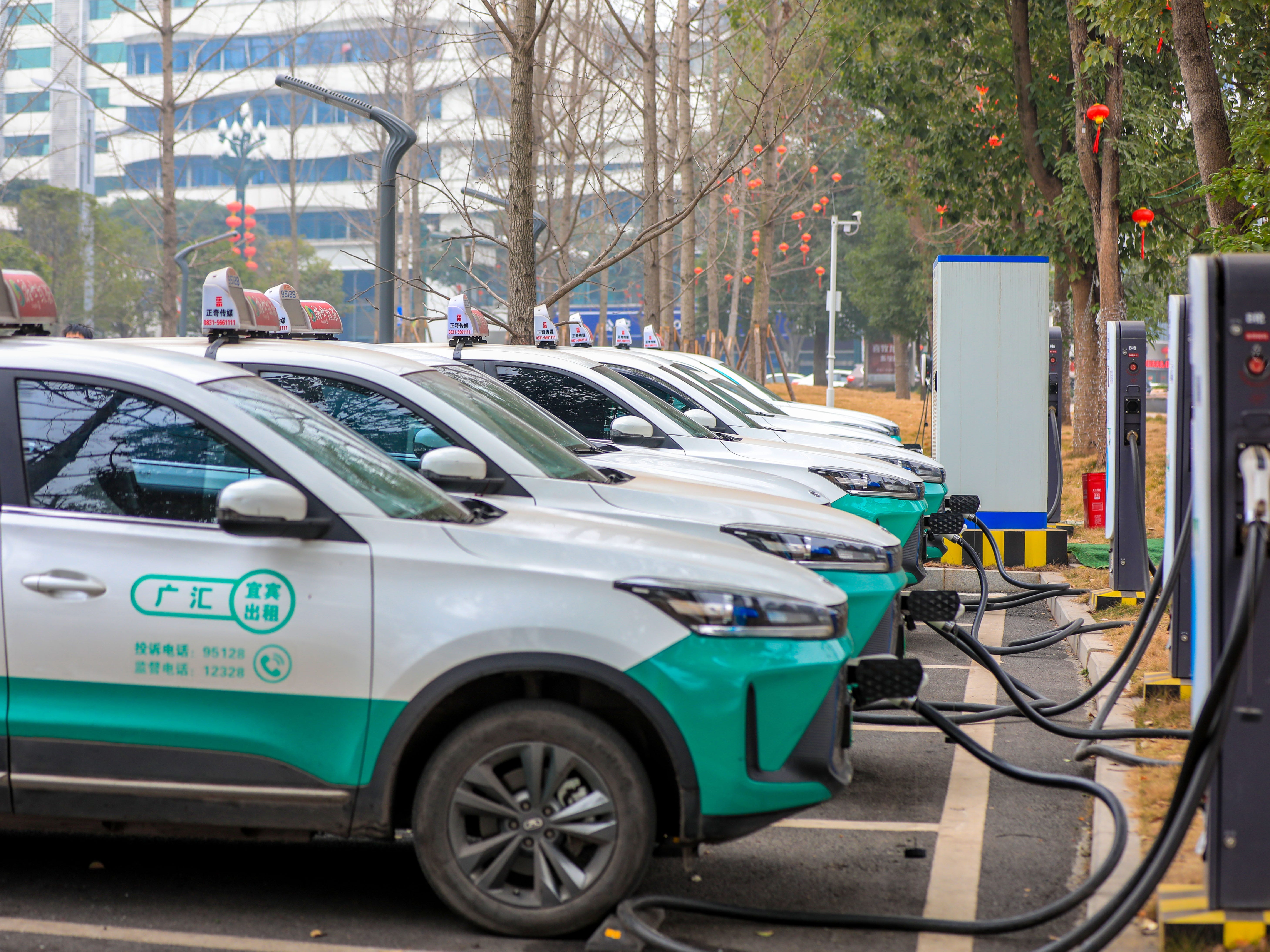 Elektryczne taksówki ładują akumulatory na stacji ładującej, 7 lutego 2023 r. W Yibin, Syczuan, Chiny.