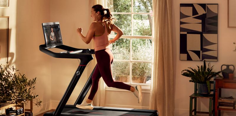 Women running on a Peloton treadmill with a touch screen display