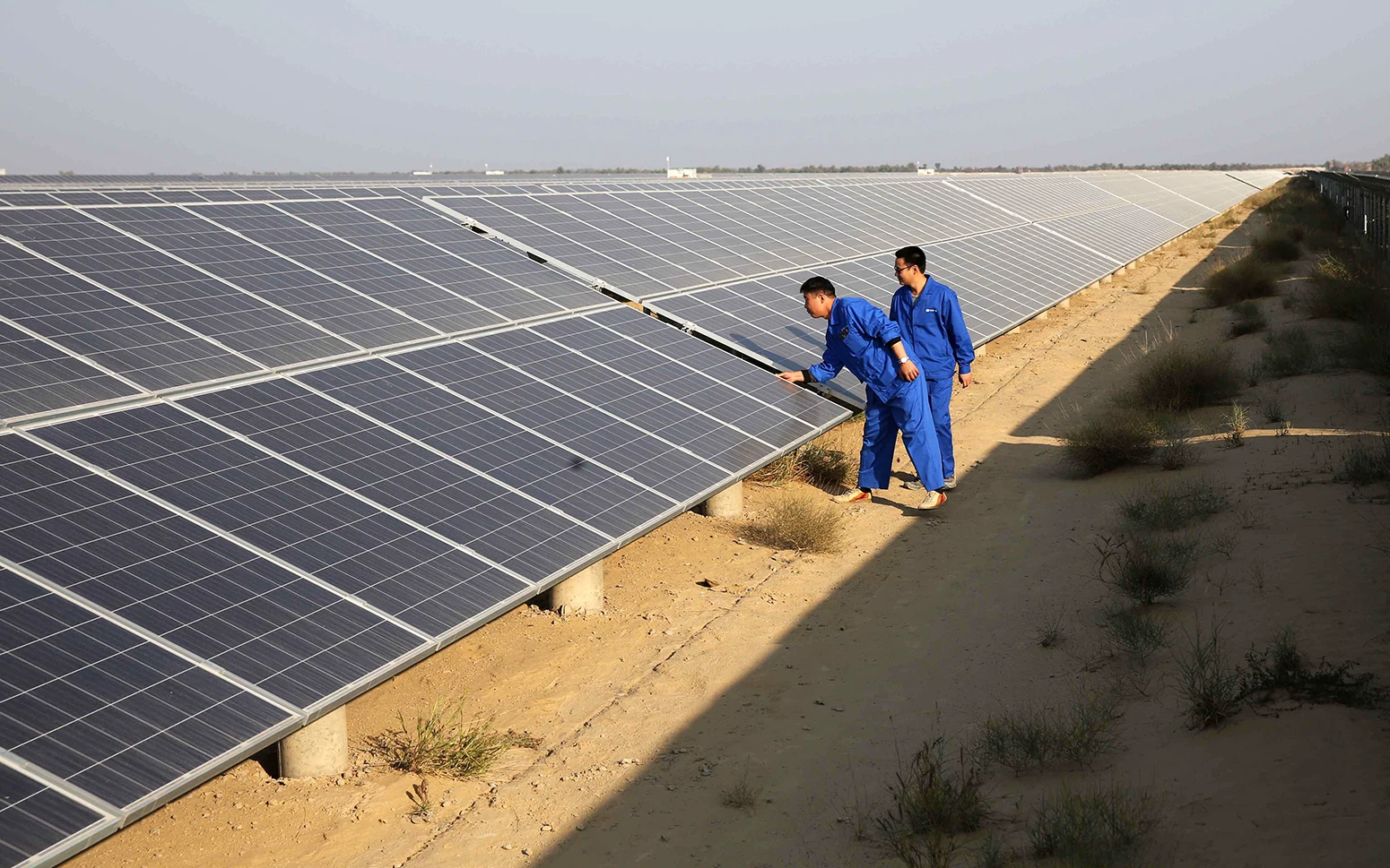 Технические специалисты проверяют солнечные панели в Бахавалпуре, Пакистан.