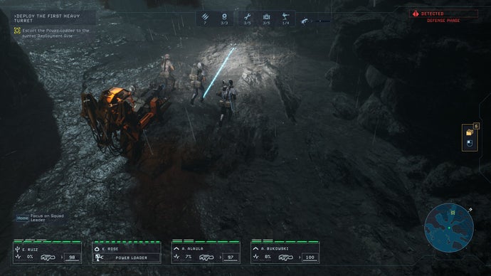 Tindalos Interactive'in Aliens: Dark Descent oyununda Lethe gezegeninin yüzeyinden bir sahne, oyuncunun deniz ekibinin çorak bir arazide turuncu bir robot yükleyiciye eşlik etmesini gösteriyor.