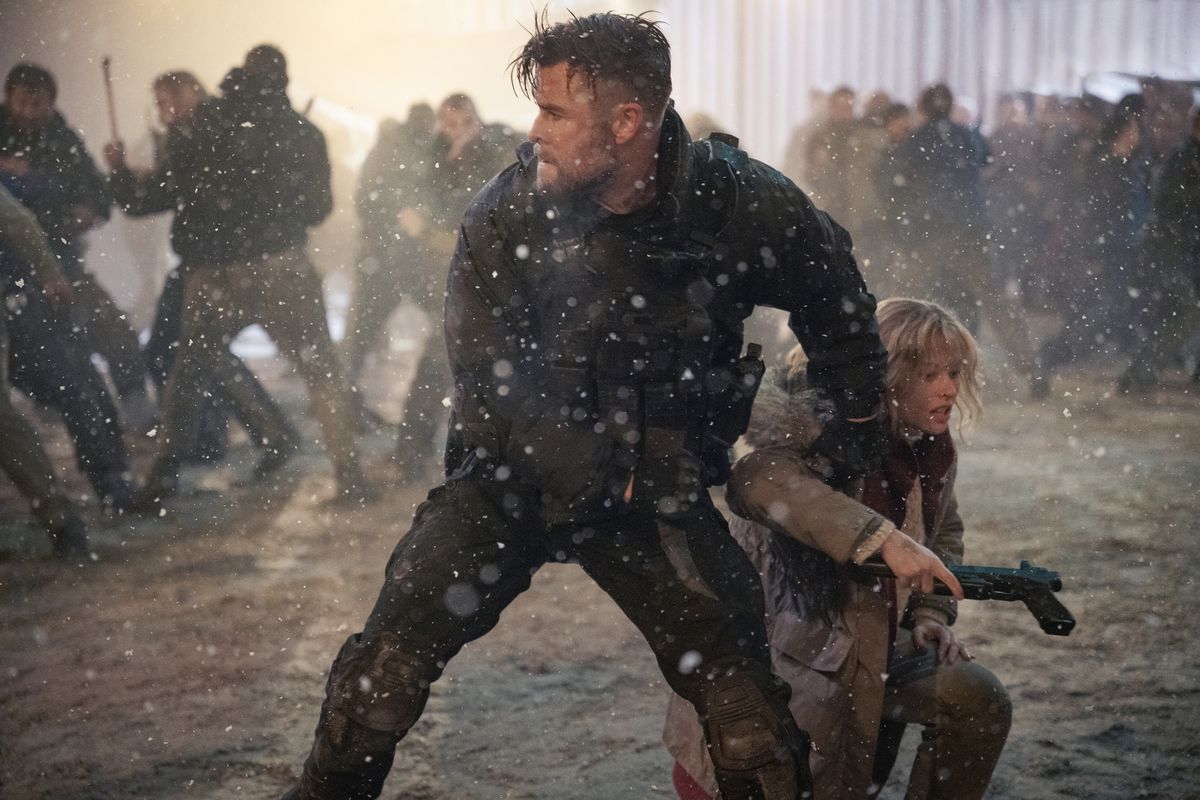 Mercenary Tyler Rake (Chris Hemsworth) stands in a snowy prison yard, surrounded by threatening thugs, and hauls his frightened-looking sister-in-law Ketevan (Tinatin Dalakishvili) to her feet in Extraction 2
