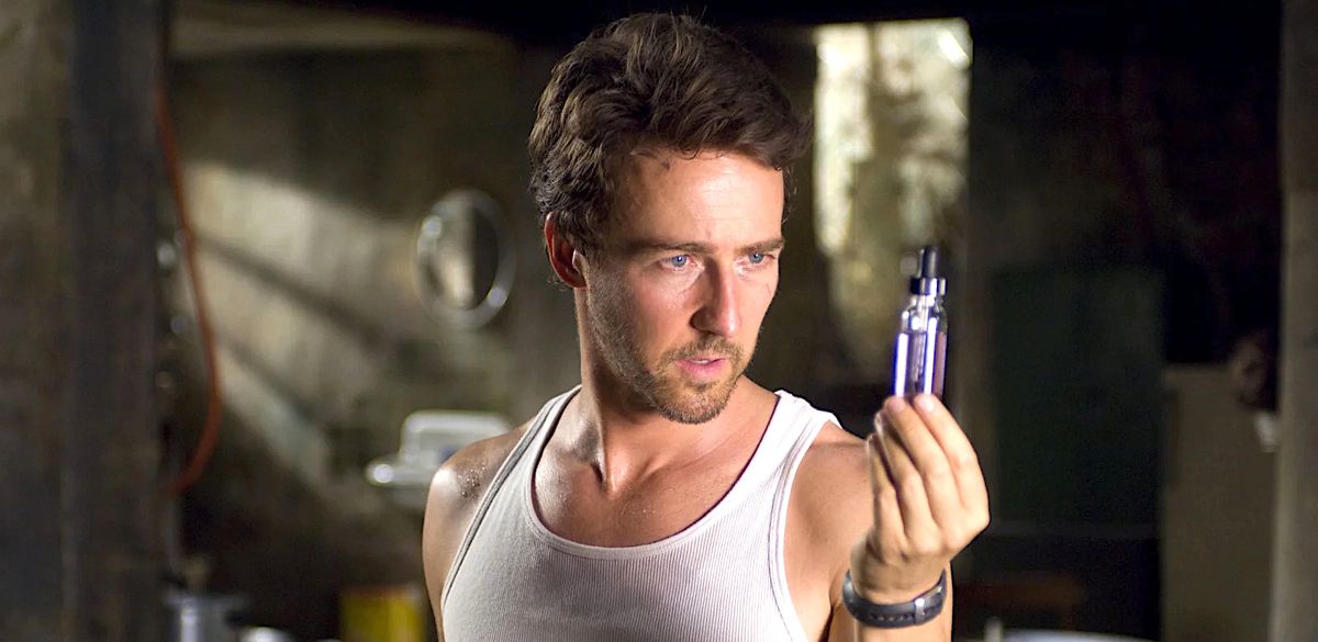 Bruce Banner (Edward Norton), in a sleeveless white T-shirt, holds up and stares at a vial of purple fluid in 2008’s The Incredible Hulk