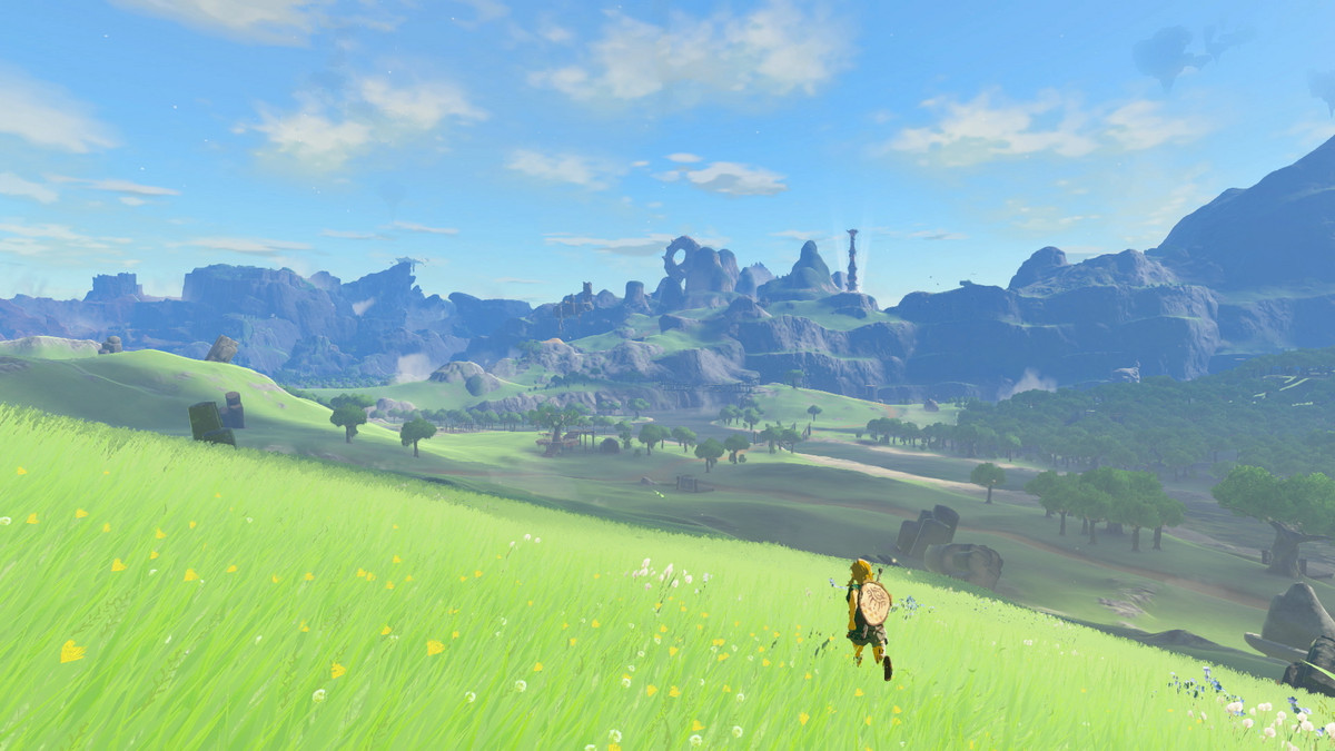 Link, a small figure in the foreground, runs across a huge open green field toward mountains in the distance in The Legend of Zelda: Tears of the Kingdom.