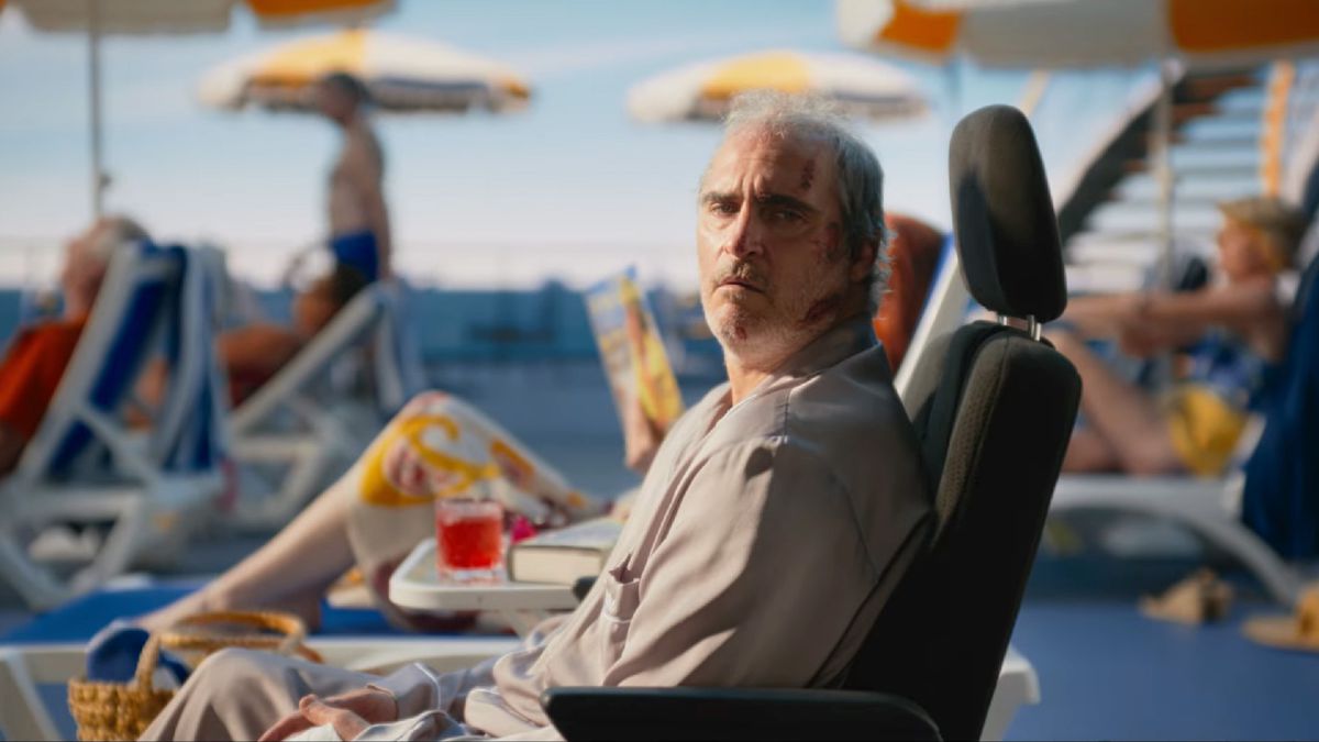Beau, played by Joaquin Phoenix, reclines on an airplane chair while on a cruise ship deck in a still from Beau Is Afraid