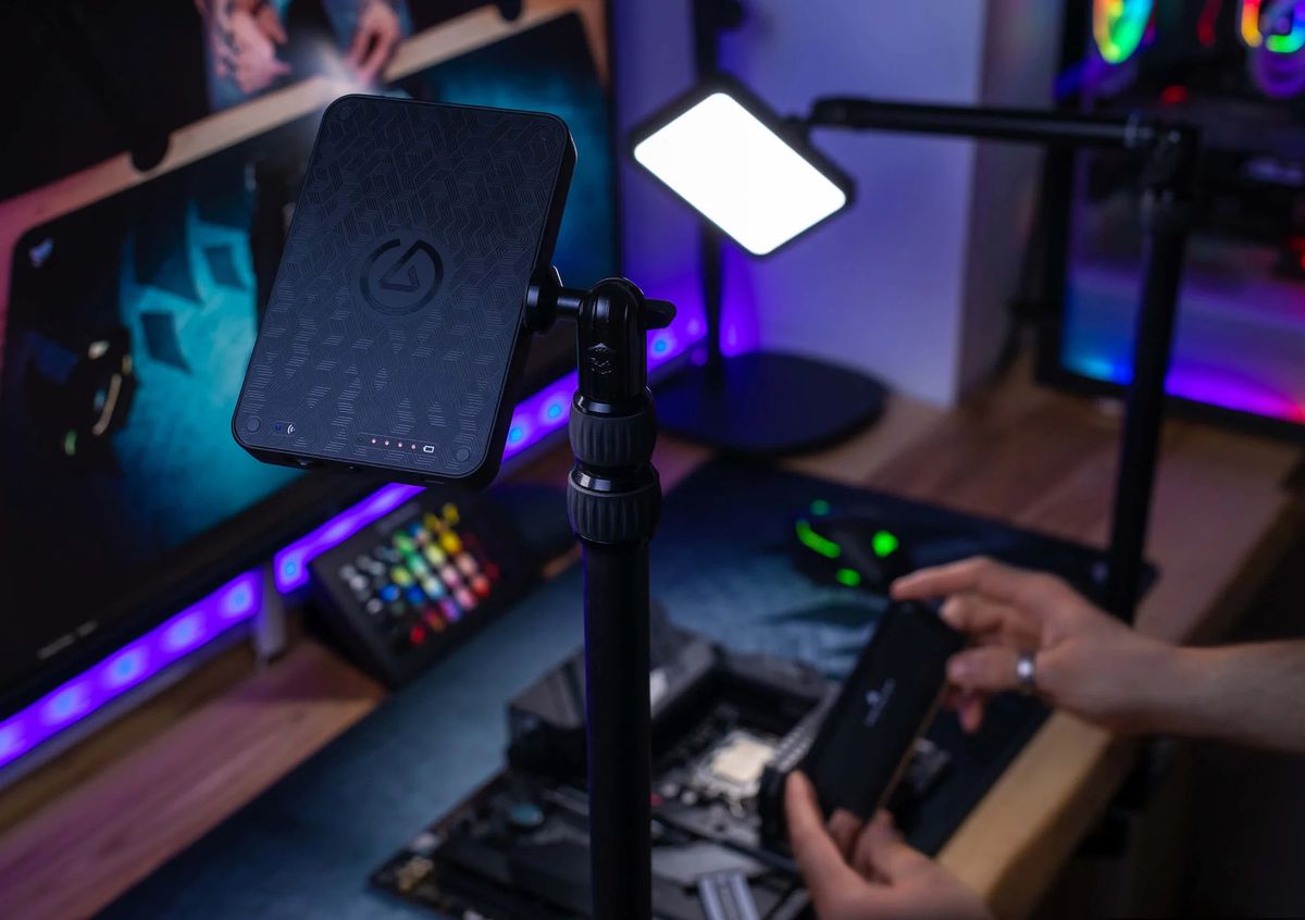 The Elgato Key Light Mini is shown from behind, shining its light onto a streamer who is building a PC from scratch.