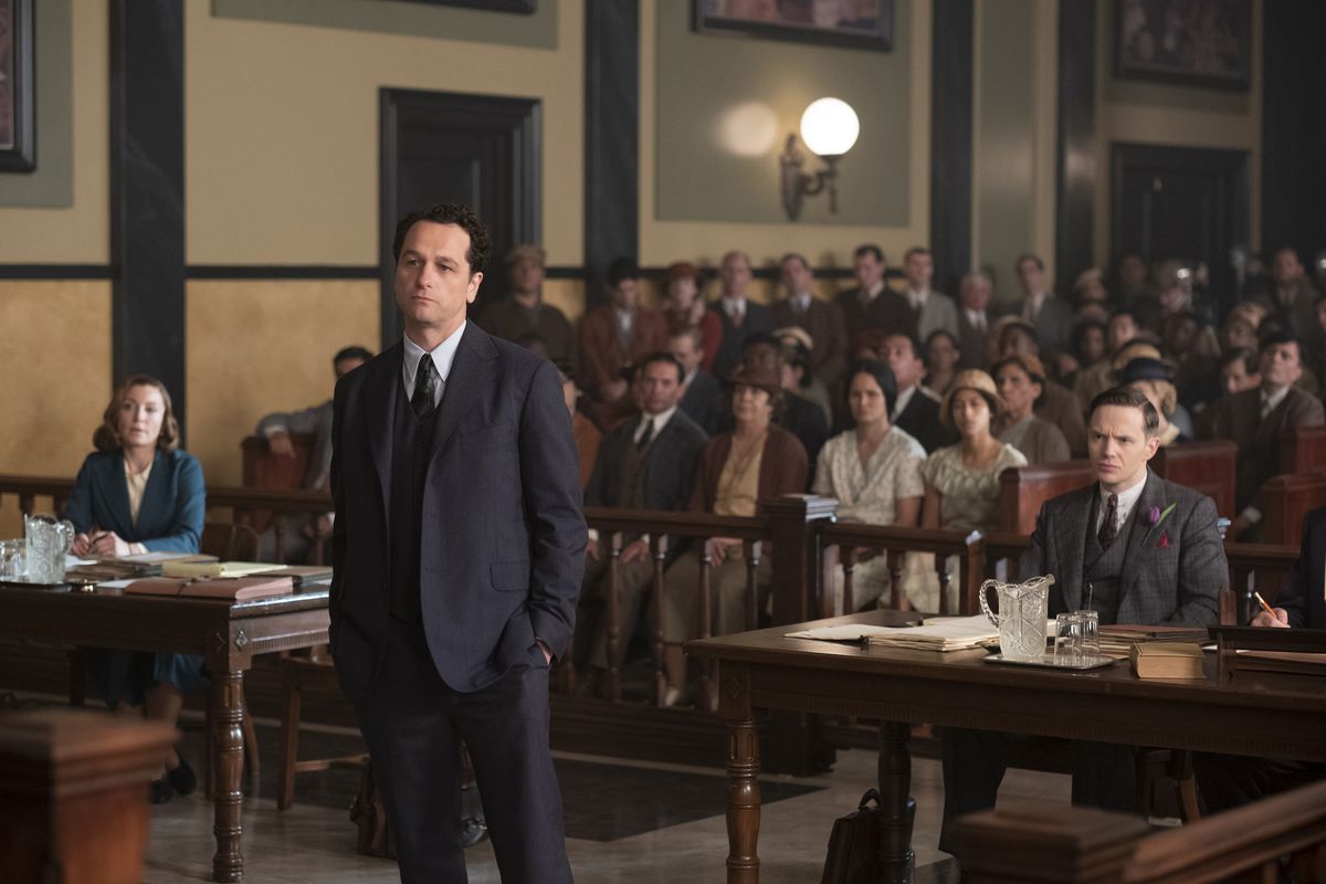 Perry Mason (Matthew Rhys) stands at a trial with the gallery looking behind him. On his right, Juliet Rylance sits at the defense’s table, while on his left, Mark O’Brien sits at the prosecution’s table.