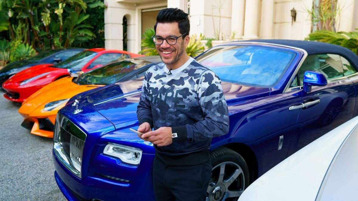 image of Tai Lopez with several luxury cars in the background