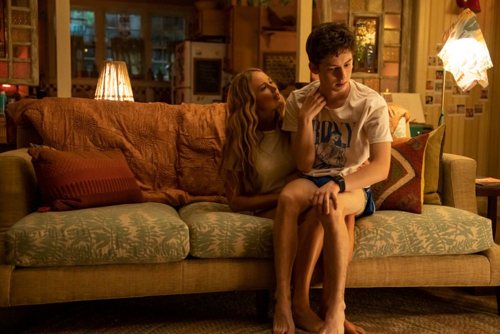 Jennifer Lawrence sidder på en sofa med Andrew Barth Feldman akavet på skødet i filmen No Hard Feelings.