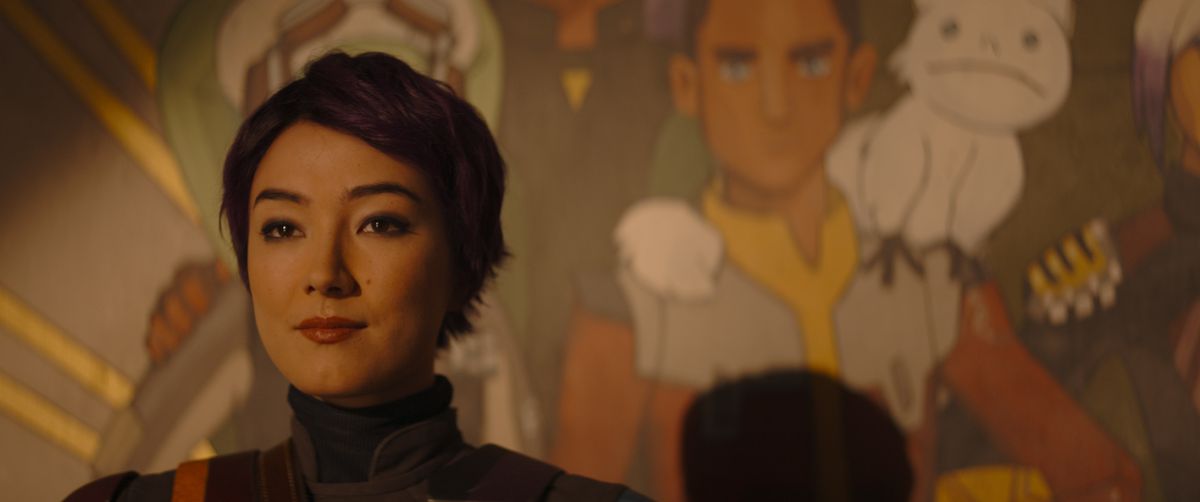 Sabine Wren (Natasha Liu Bordizzo), with short hair, stands in front of her mural of the crew of the Ghost —&nbsp;Ezra is clearly visible —&nbsp;in Star Wars: Ahsoka.