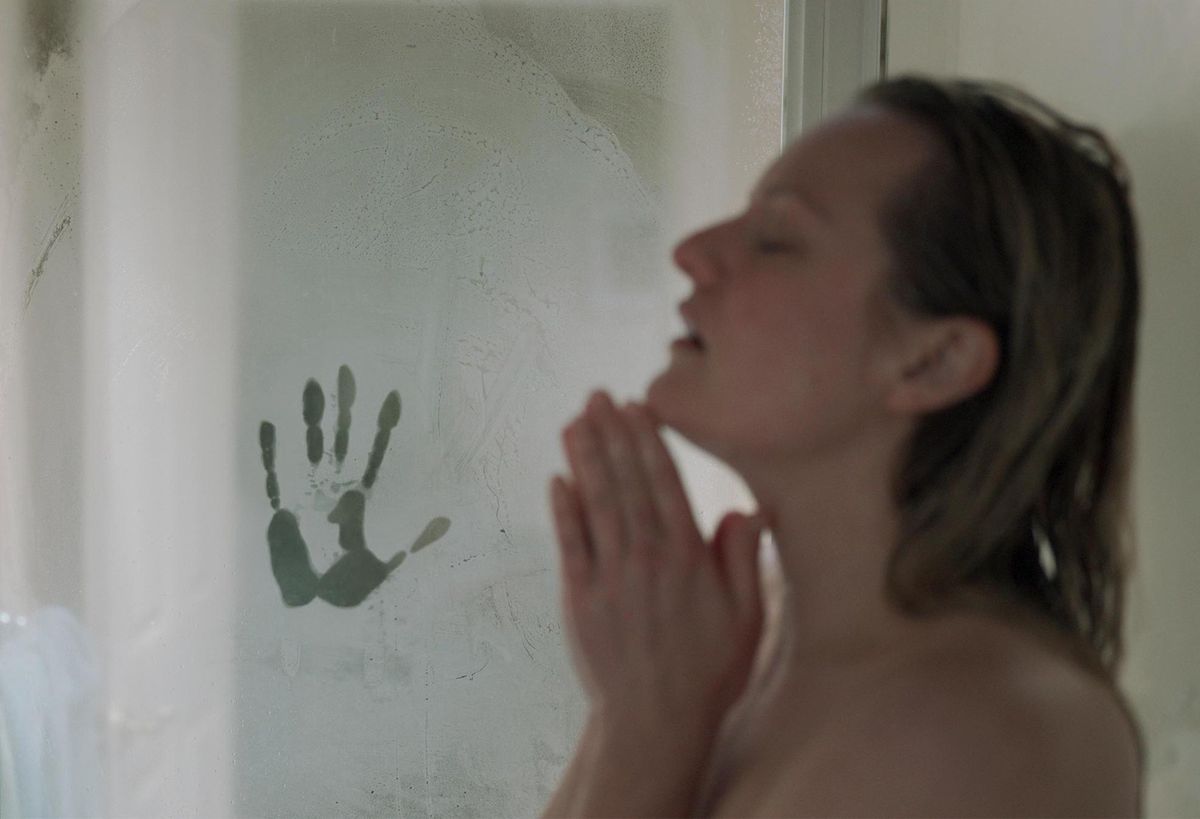 Elisabeth Moss in the shower with a mysterious handprint on the fogged-up door in The Invisible Man