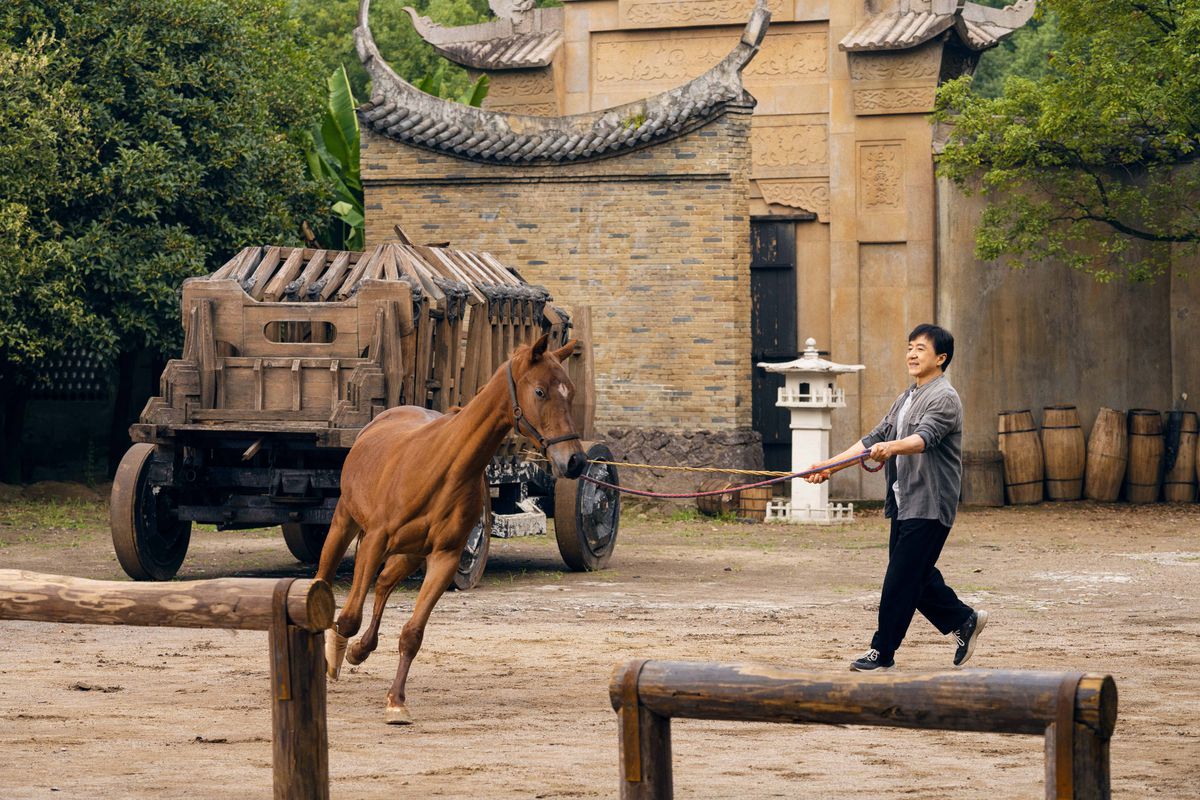 Лошадь скачет по открытой местности, пока Джеки Чан инструктирует по программе Ride On.