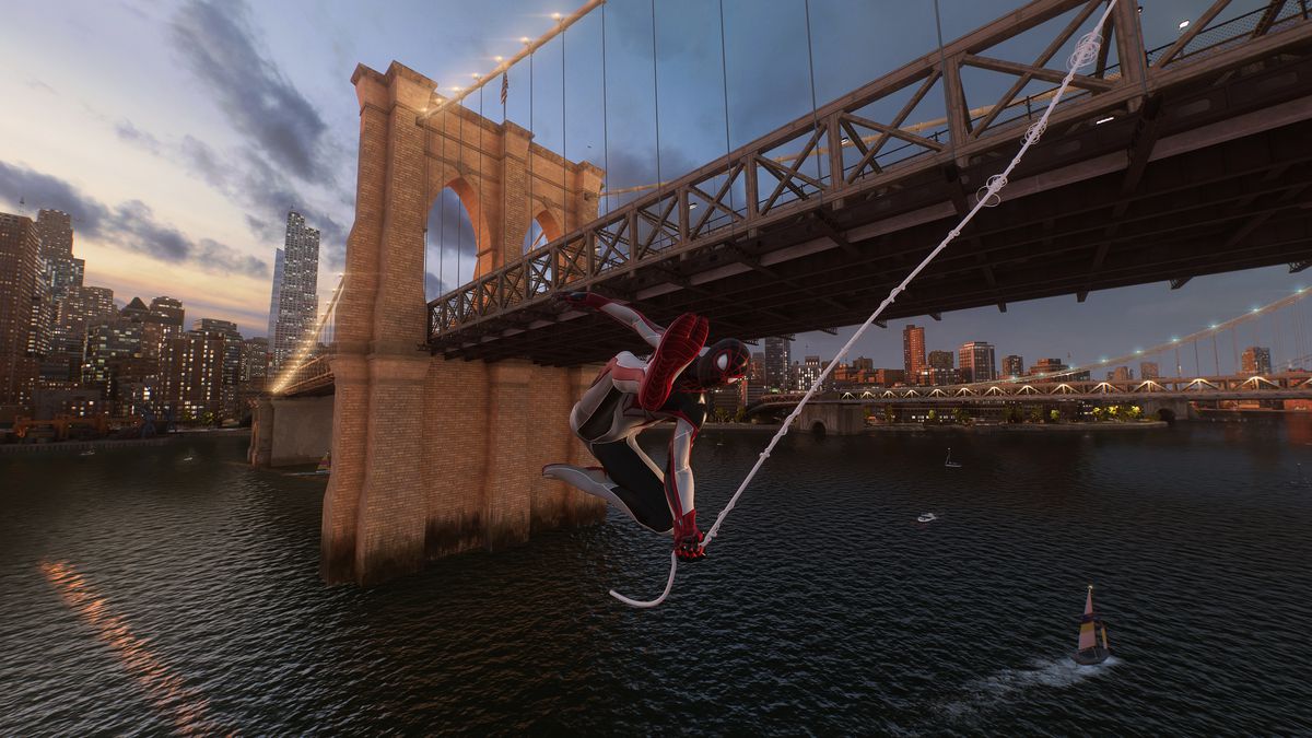 Miles Morales swings beneath Brooklyn Bridge at dusk in Marvel’s Spider-Man 2