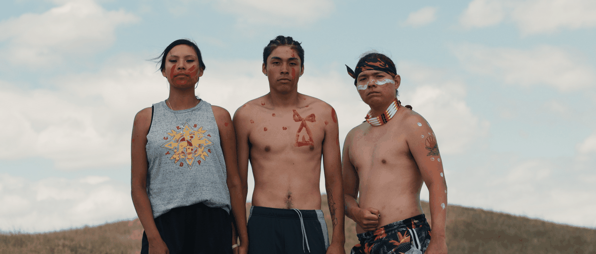 Three protestors wearing face and body paint in Lakota Nation vs. United States.