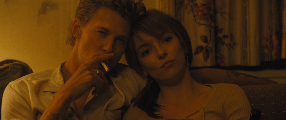 Austin Butler smokes and looks cool while leaning his head on Jodie Comer’s head in The Bikeriders