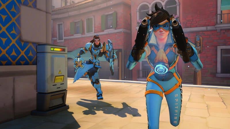 Overwatch heroes Tracer and Brigitte round a corner in-game wearing the London Spitfire skins.