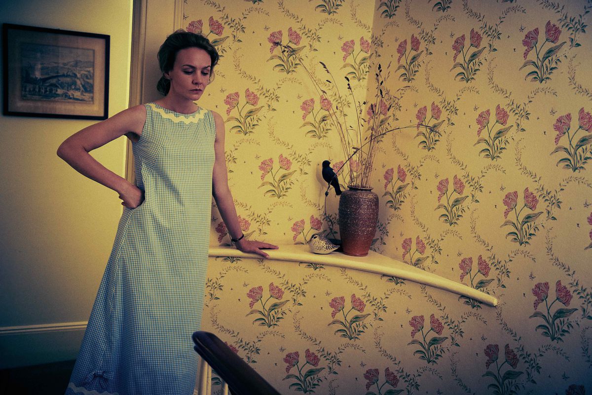 Carey Mulligan stands in a nightgown at the top of a staircase in a scene from Netflix’s Maestro