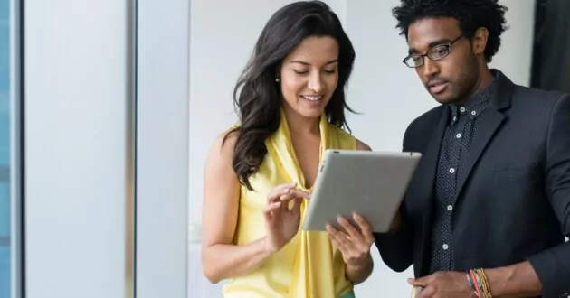 Hispanic business people using digital tablet in office