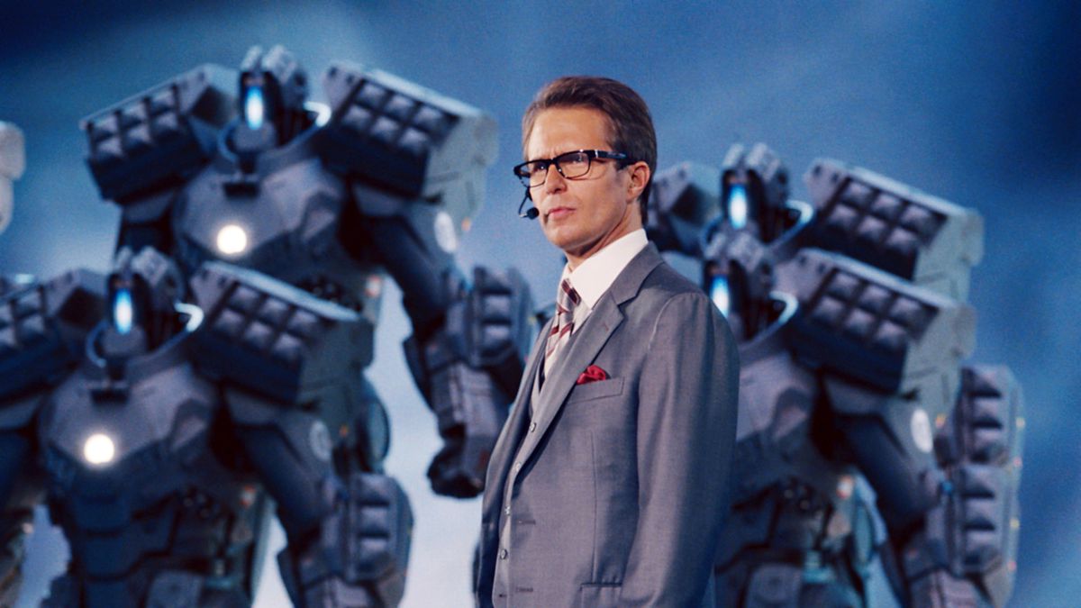 Sam Rockwell as Justin Hammer giving a talk in front of some armored drones with missle launchers on their back in Iron Man 2