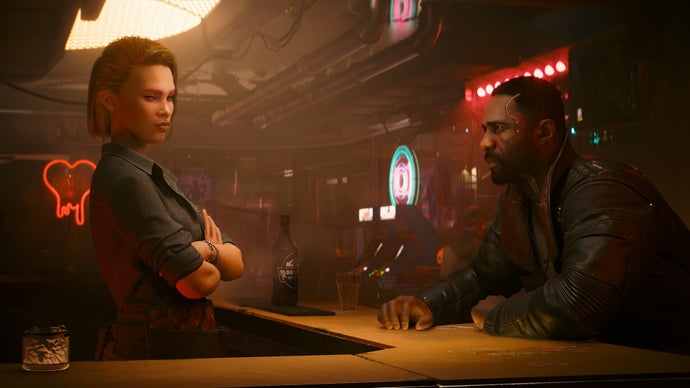 Tangkapan layar resmi Cyberpunk Phantom Liberty menunjukkan karakter Idris Elba duduk di seberang bar sambil memandangi bartender wanita di ruangan berwarna coklat kabur.