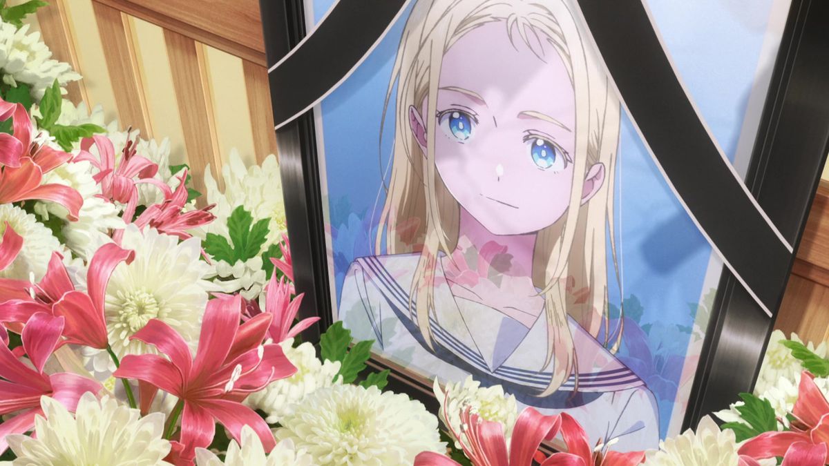 Közeli felvétel egy szőke hajú, kék szemű lány temetési portréjáról, virágokkal körülvéve.