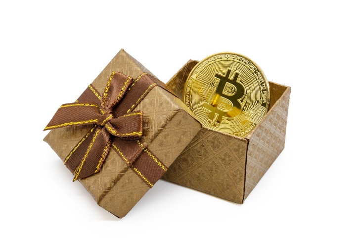 نماد بیت کوین روی یک سکه طلا در جعبه هدیه طلایی