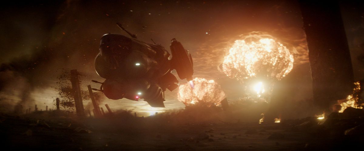 Un vaisseau spatial volumineux et trapu décolle du sol, se découpant sur quelques explosions de champignons au loin dans une photo de Rebel Moon Part One: A Child of Fire.