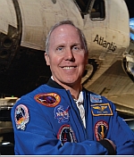 Astronaut Tom Jones standing in front of the Atlantis Space Shuttle