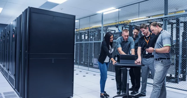 Пять сотрудников анализируют риски для серверов на компьютере и реализуют стратегию снижения рисков.