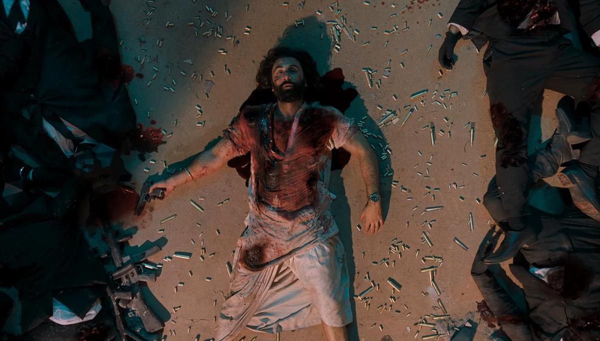 Ranbir Kapoor stă întins la pământ cu o cămașă însângerată și înconjurat de cadavre și carcase de gloanțe în Animal