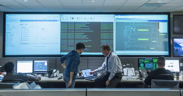 همکارانی که در اتاق کنترل سرور برای امنیت داده ها و مدیریت داده ها، با استفاده از روش های تست نفوذ، با هم کار می کنند