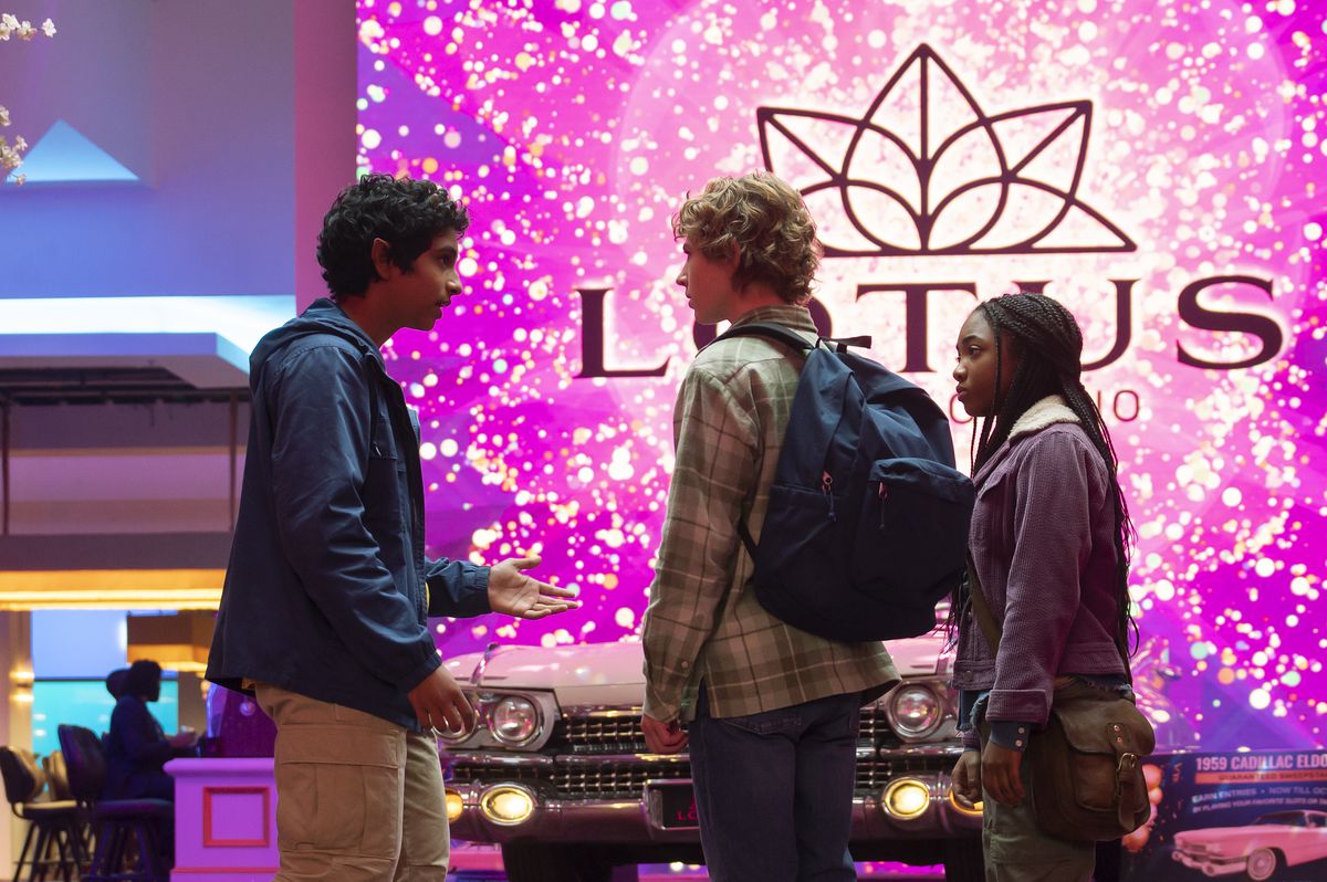 Grover talking to Percy and Annabeth, as they stand in front of the glitzy Lotus Hotel and Casino entrance