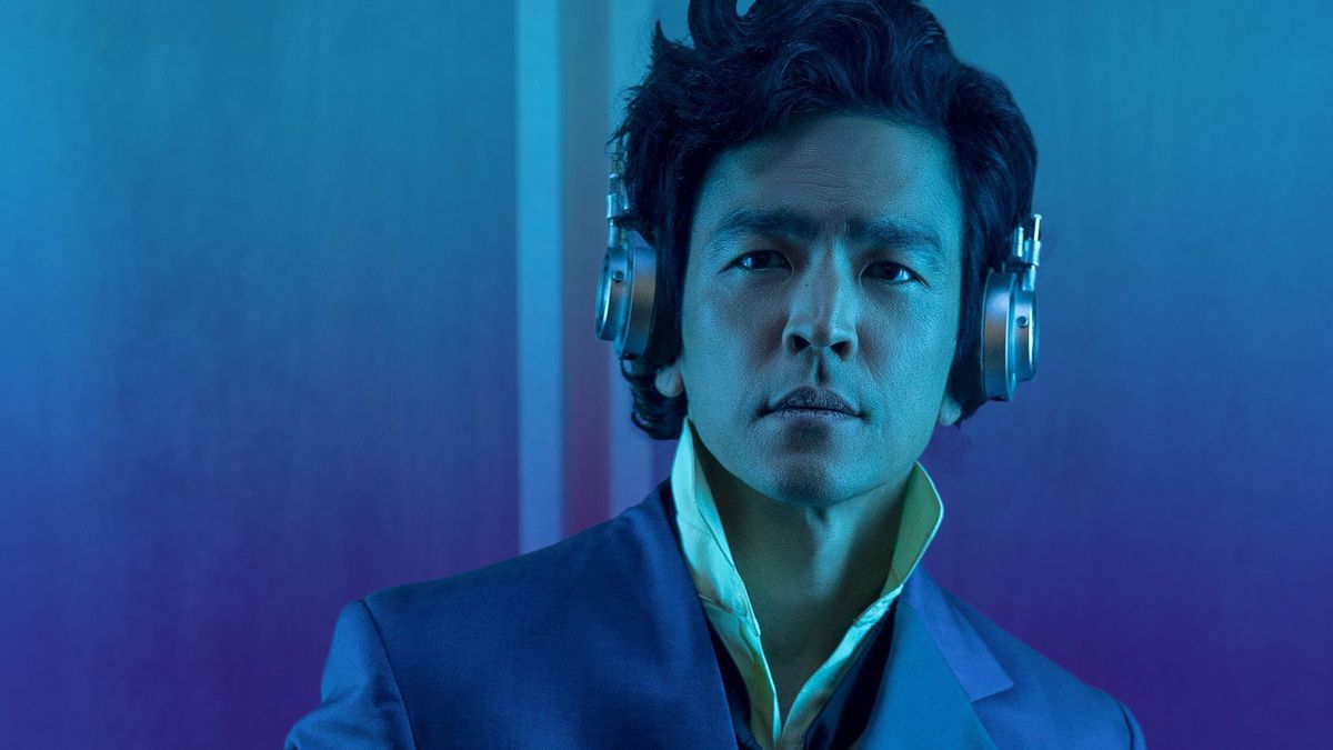 Φωτογραφία ενός άνδρα που φοράει ακουστικά που στέκεται σε μπλε φόντο