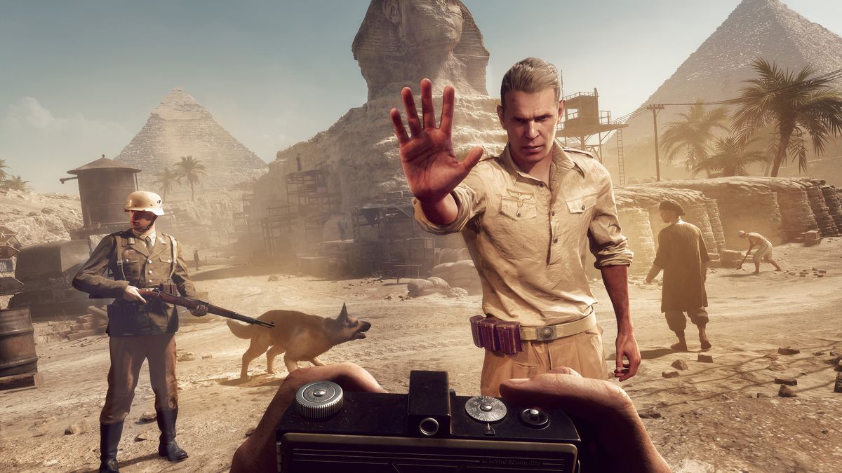 Első személyű kép Indiana Jones szemszögéből, ahogy egy őr megállítja őt egy egyiptomi területen, a háttérben egy szfinxszel és piramisszal az Indiana Jones és a nagy kör játékból.